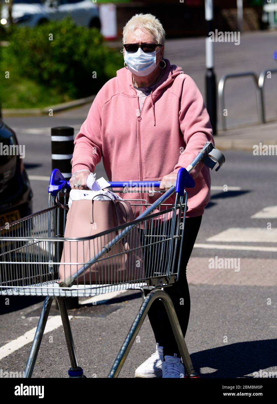 Elderly woman with shopping trolley en route to supermarket wearing face mask during the Coronavirus (COVID-19) pandemic, Haslemere, Surrey, UK. Stock Photo