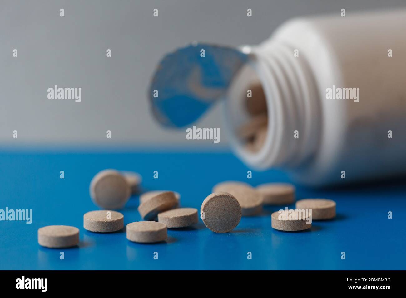 Brewer's yeast tablets. Dietary supplement. Pills poured from a jar on