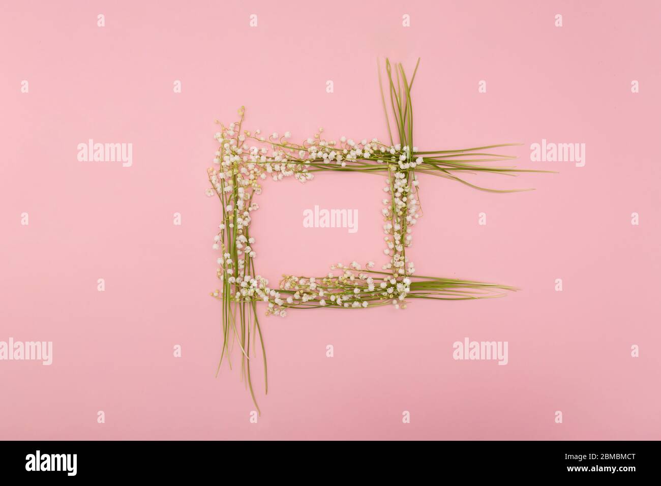 Flower composition from lily of the valley making frame on pink ...