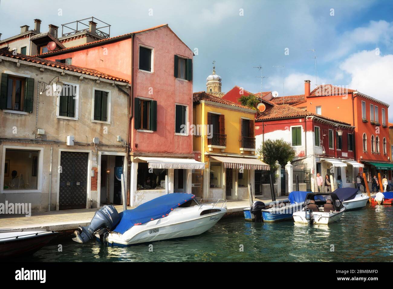 Canal with boats and colourful houses on the island of Murano, Italy ...