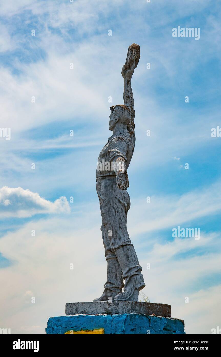 Silhouette of Soviet worker statue with sky background. Social realism monument in Odessa countryside of Ukraine Stock Photo
