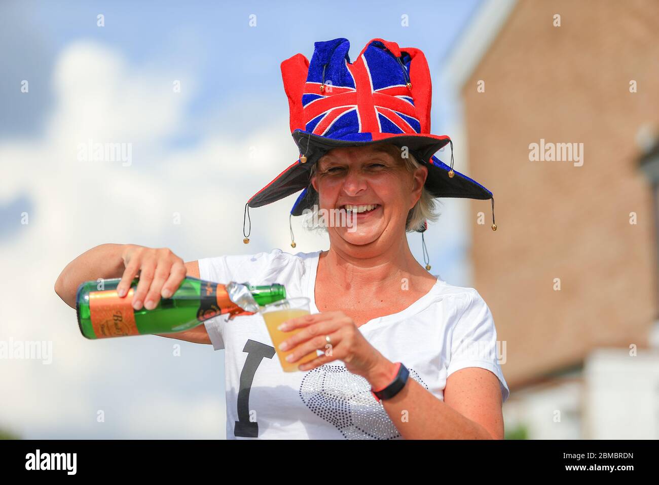 Halesowen, West Midlands, UK. 8th May, 2020. Samantha Grinham, 50, enjoys a bucks fizz at her VE Day 75 street party in Halesowen, West Midlands. Credit: Peter Lopeman/Alamy Live News Stock Photo