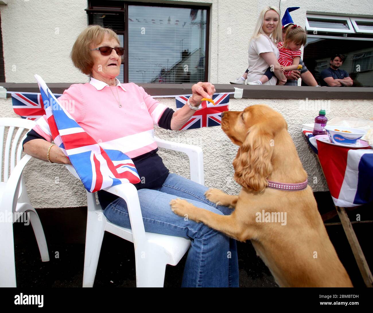 Bushmills, Northern Ireland 8th May 2020..Margaret McVicker and her dog Lily celebrate VE Day in their Garden in Bushmills.. Pic Steven McAuley/McAuley Multimedia Credit: Steven McAuley/Alamy Live News Stock Photo