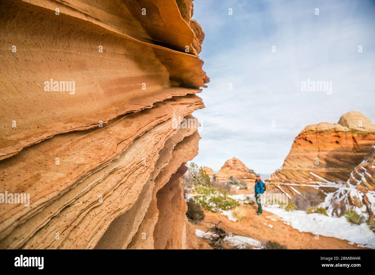 Sandstone lace rock and hiker for scale, Vermilion Cliffs Stock Photo
