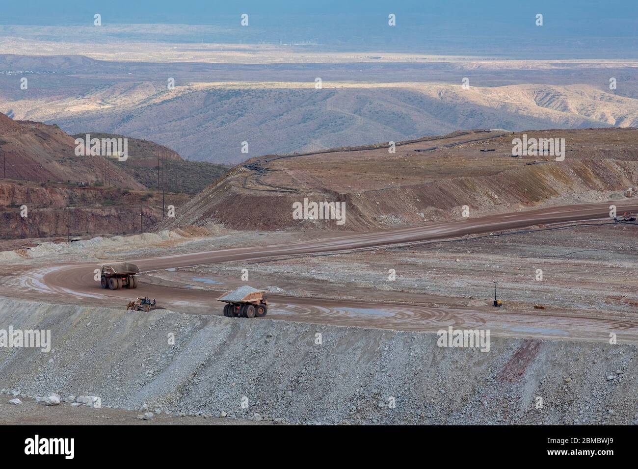 Dump trucks haul earth from strip mine operation in remote area Stock Photo