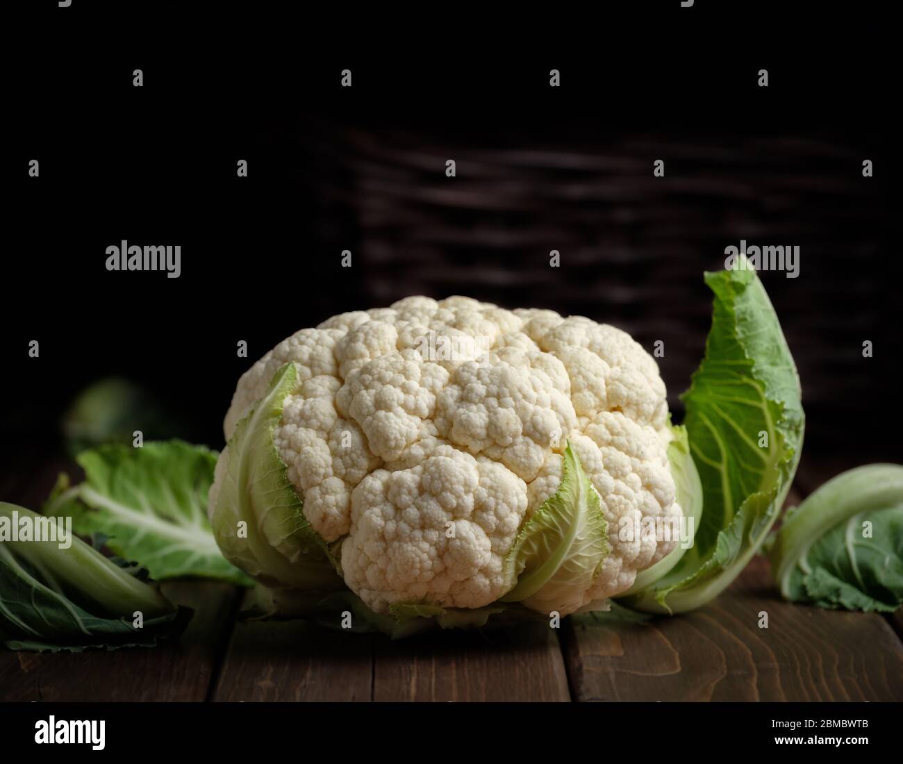 vegetable cauliflower head fresh raw vegan food ingredient still life dark wood background with copy space Stock Photo