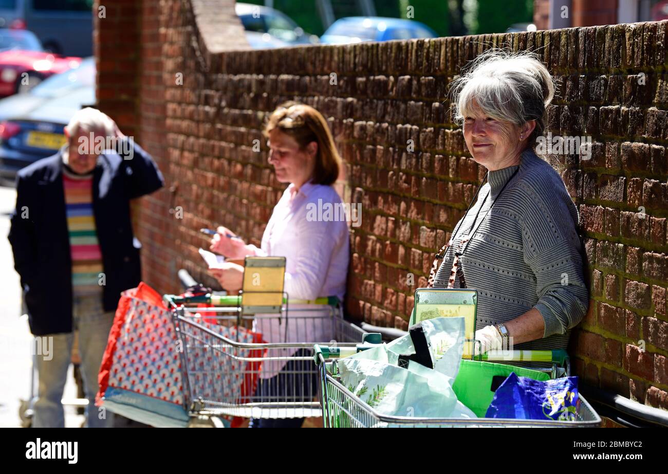 Shoppers wait in line to enter supermarket during social distancing measures introduced because of the Coronavirus (COVID-19) pandemic, Haslemere, UK. Stock Photo