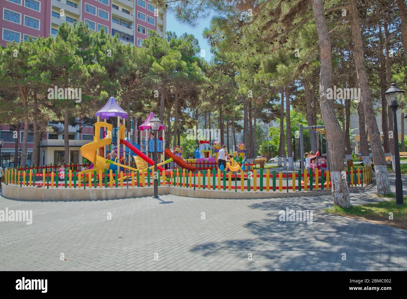 Children kids playground with play equipment outdoor. Kids playground with slides in the park. Pine trees . play ground colorfull big plastic toy set Stock Photo