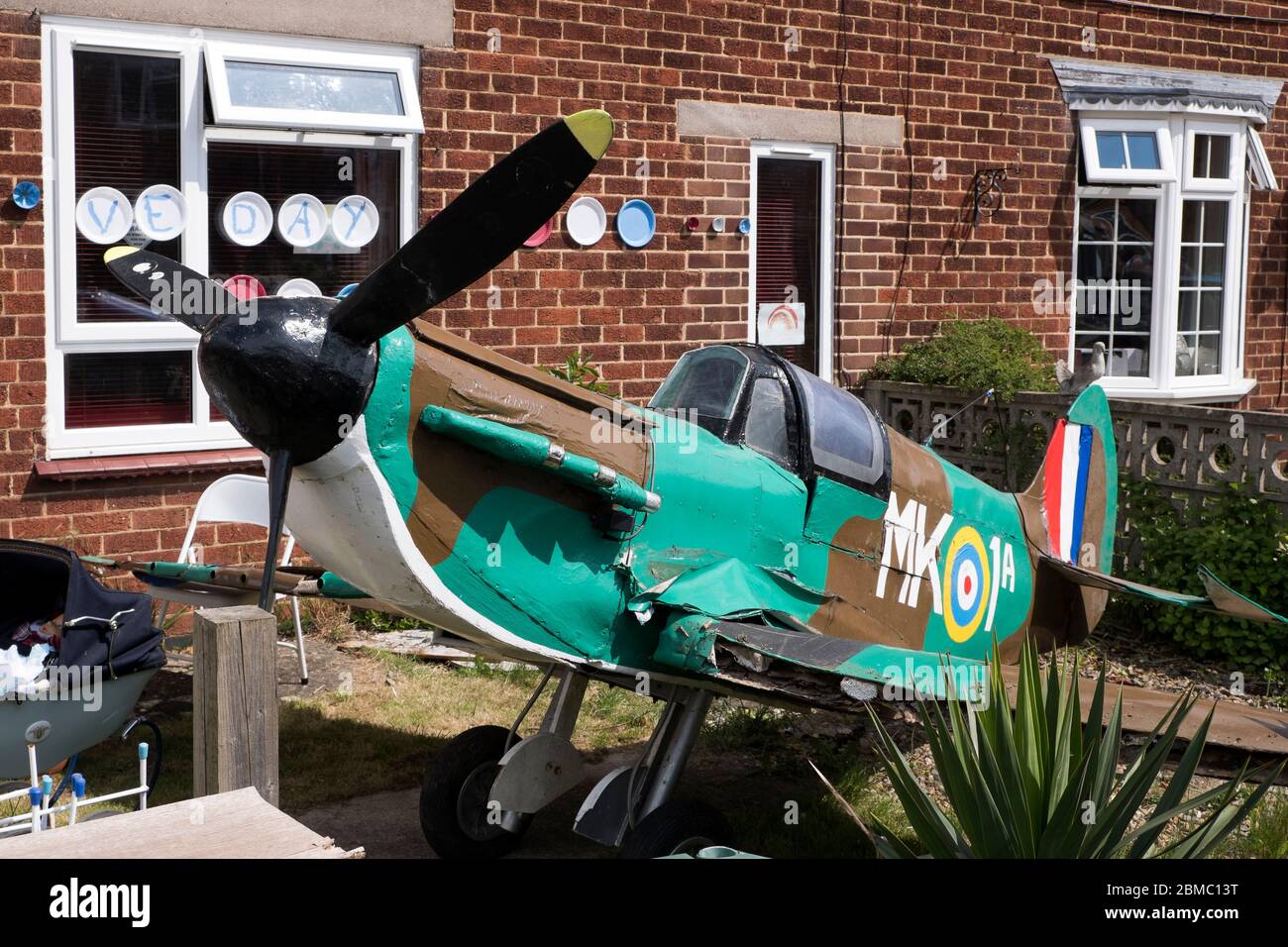 A large scale model Spitfire fighter plane in a front garden in Bugbrooke, Northamptonshire Stock Photo