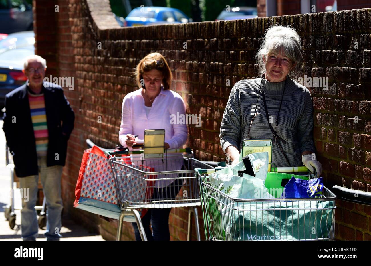 Shoppers wait in line to enter supermarket during social distancing measures introduced because of the Coronavirus (COVID-19) pandemic, Haslemere, UK. Stock Photo