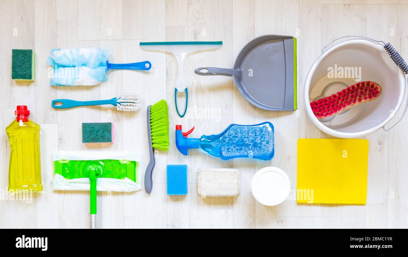 Flat lay with collection of cleaning materials on a light wooden background Stock Photo