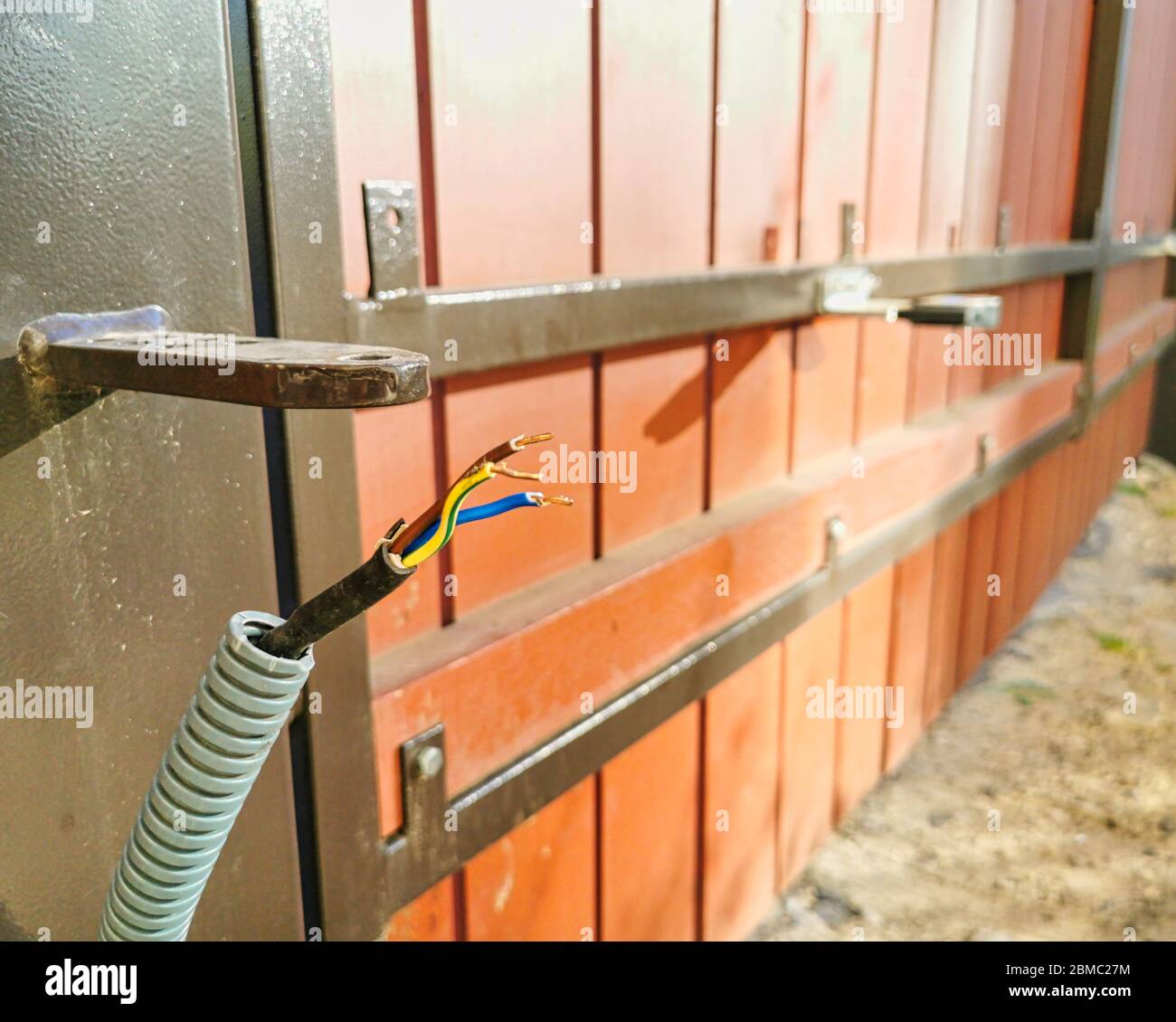 Remote control automatic electric gate install with wiring close up. Setup concept Stock Photo