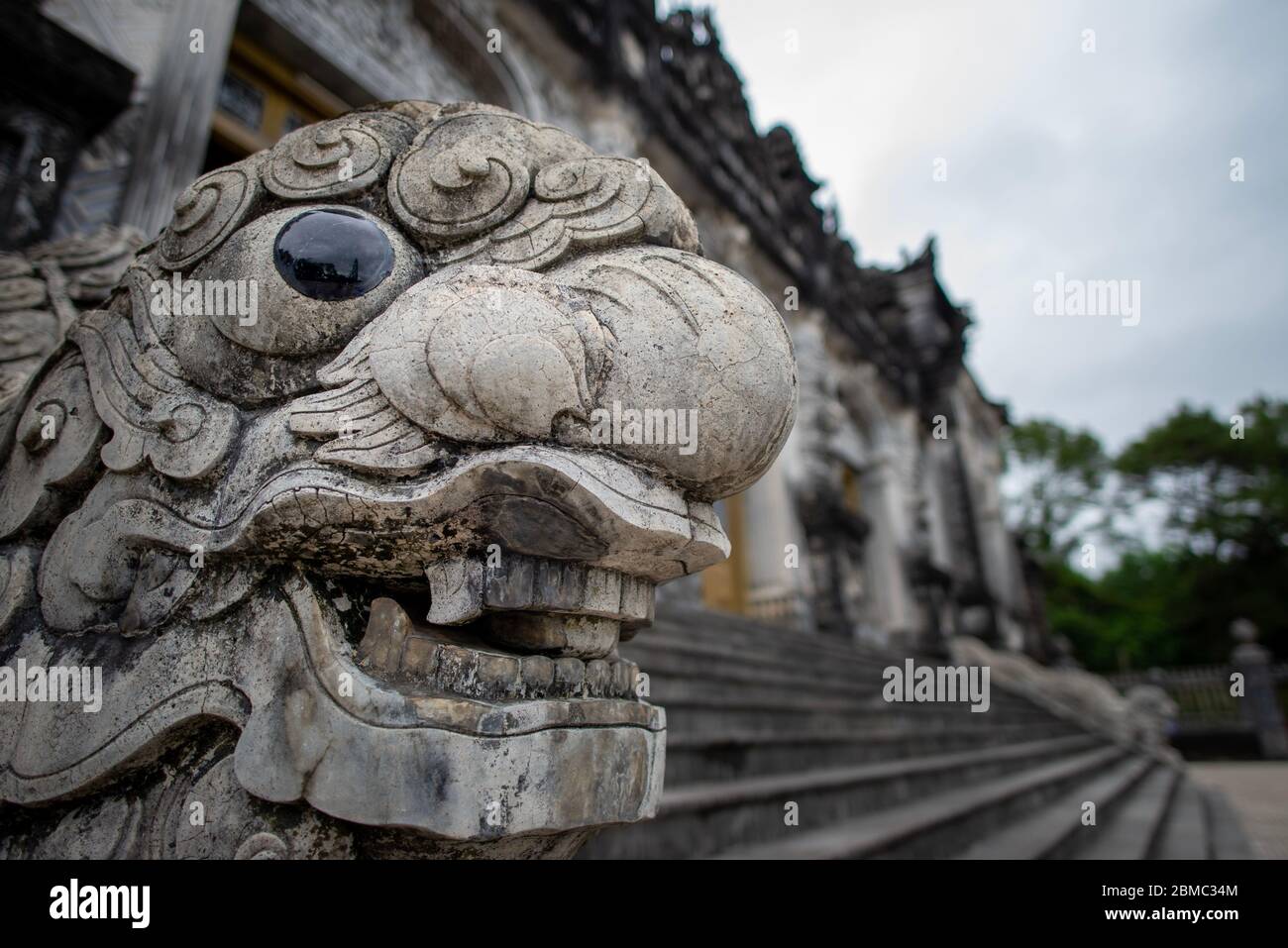 Hue, Vietnam - April 16, 2018: Dragon's head at the Emperor Khai Dinh tomb, with no people and an overcast sky Stock Photo
