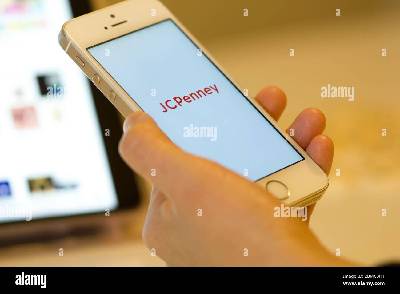 A woman opens the American department store chain JCPenney Company, Inc.'s mobile app from her smartphone. Stock Photo