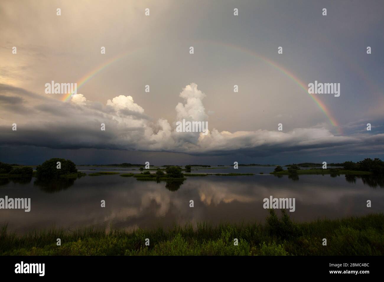 Full Rainbow over Storm Clouds Stock Photo
