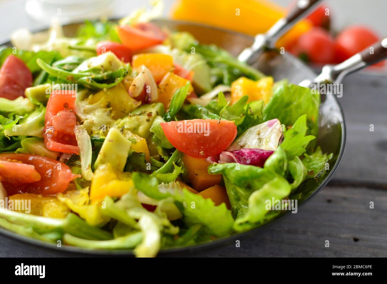 Healthy vegan food. Vegetable salad dressing, tomatoes, bell peppers, avocado. Close-up. Vegetarianism and veganism. Stock Photo