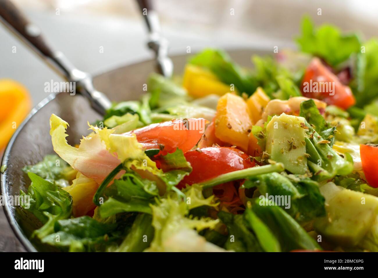 Healthy vegan food. Vegetable salad dressing, tomatoes, bell peppers, avocado. Close-up. Vegetarianism and veganism. Stock Photo
