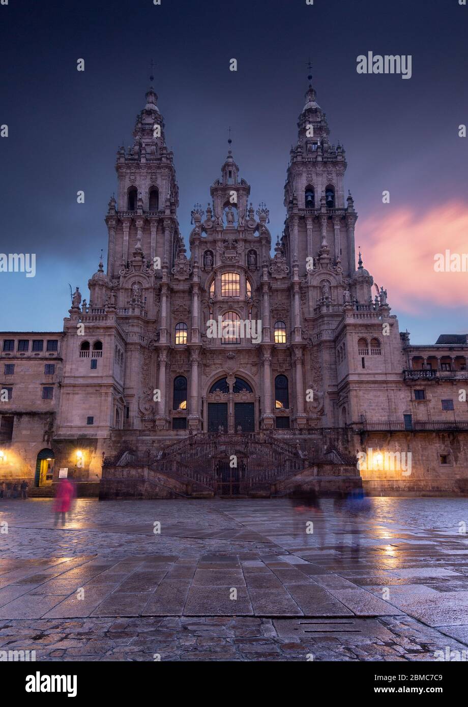 People is crossing the Obradoiro square in the final step of santiago pilgrimage path, making ghost shadows in this rainy day. Stock Photo