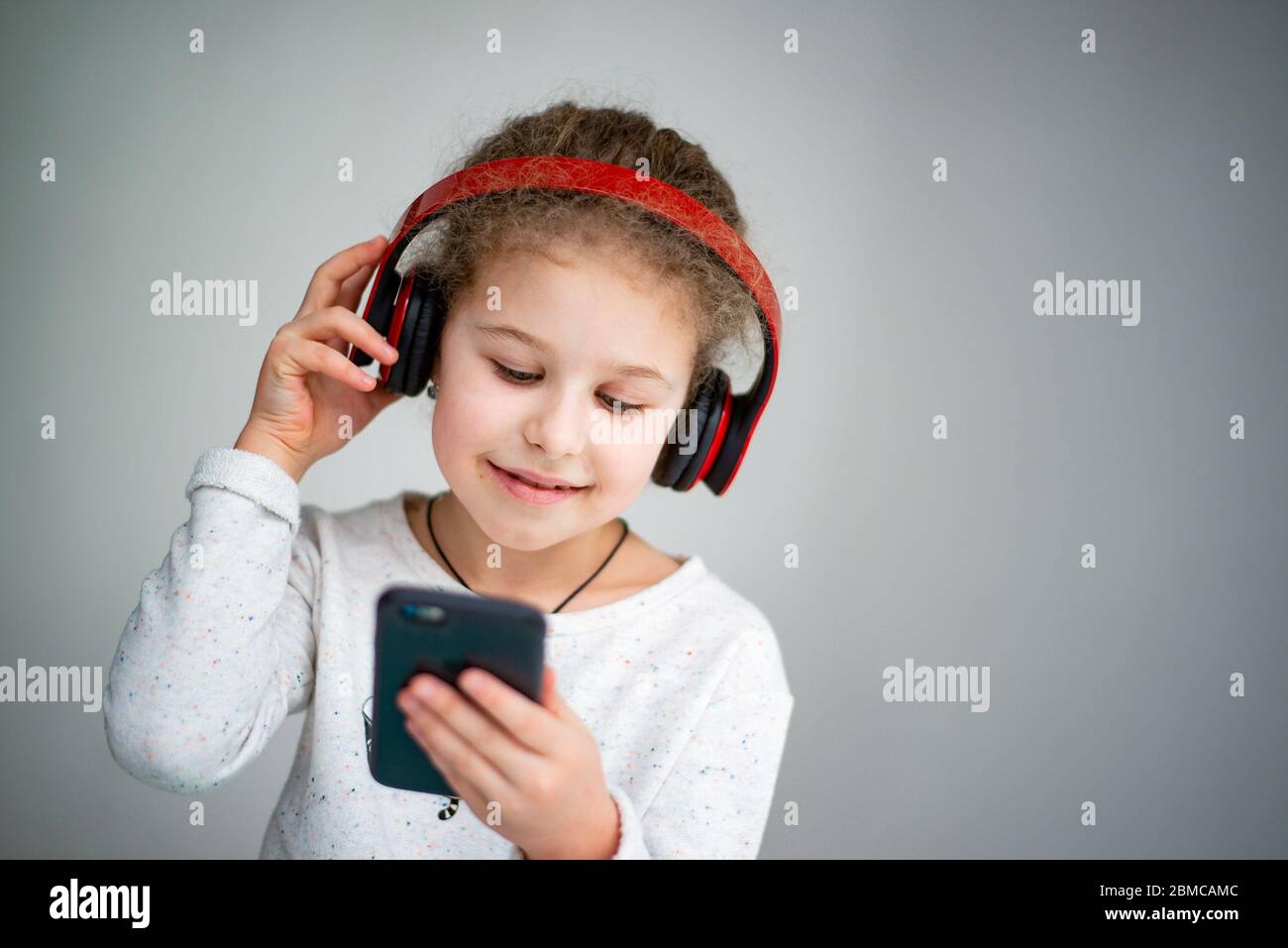 little girl in red headphones with a phone Stock Photo Alamy