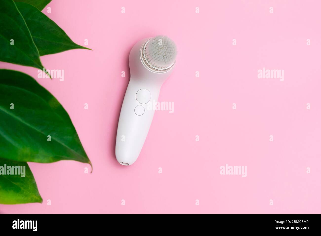 Face cleansing brush on pink background, top view, space for text Stock Photo