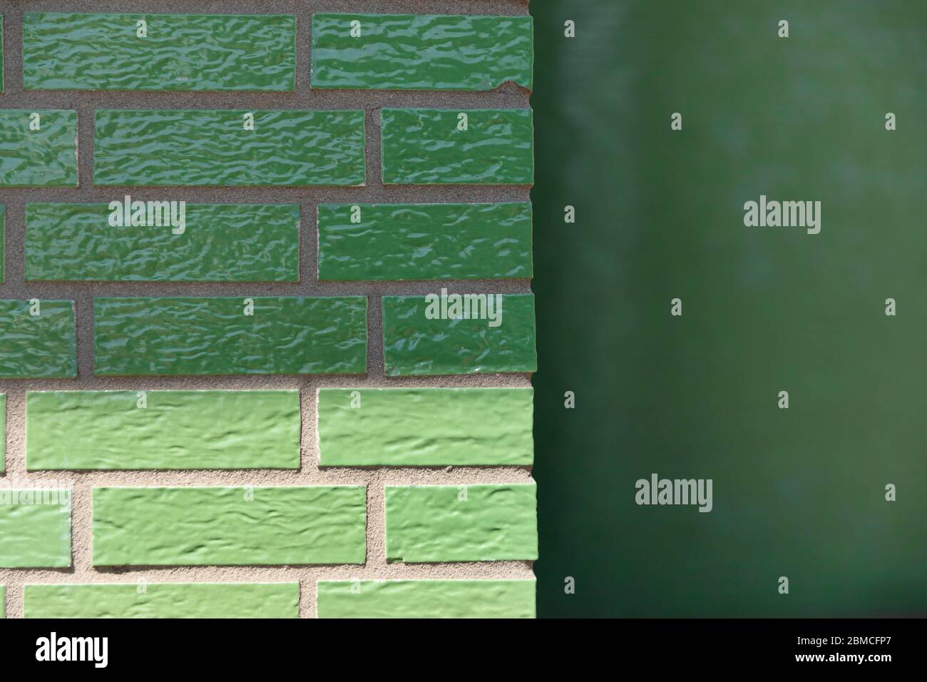 A glazed enamelled green brick wall creating a retro vintage effect on