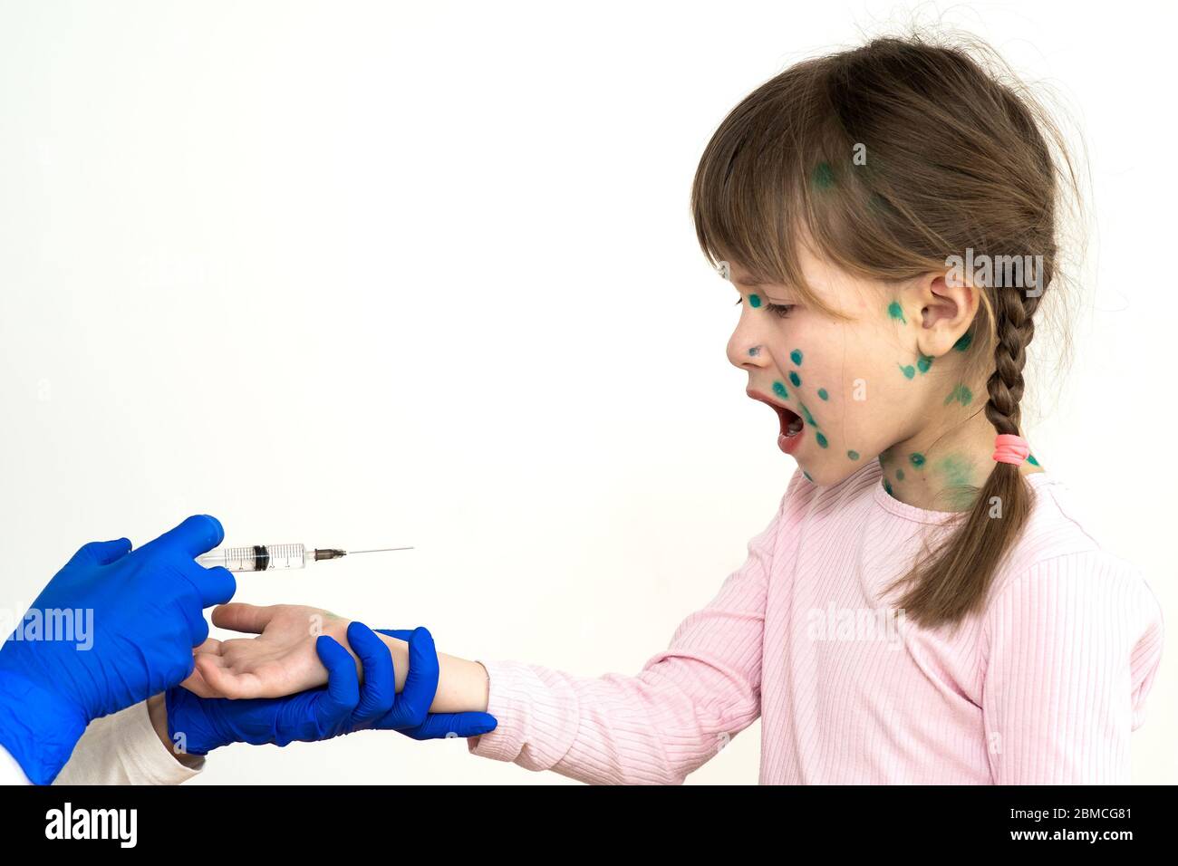 Doctor making vaccination injection to an afraid child girl sick with chickenpox, measles or rubella virus. Vaccination of children at school concept. Stock Photo