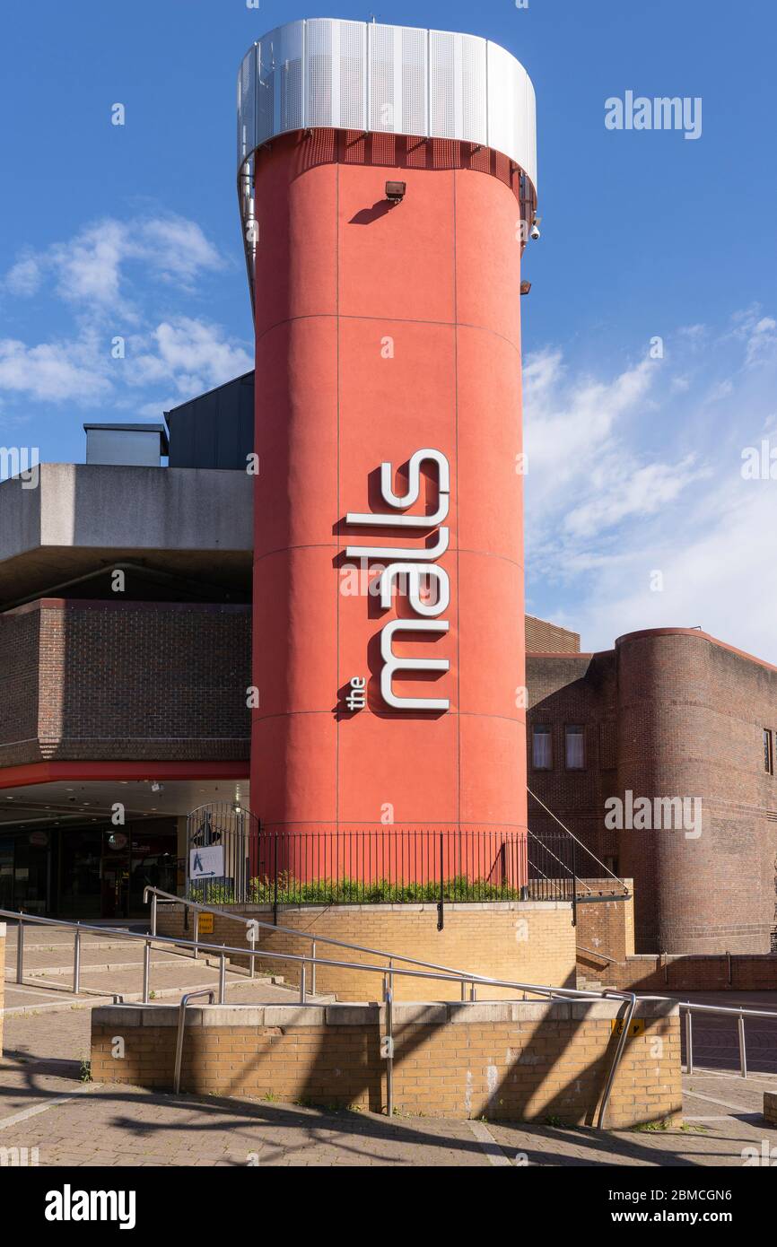 A large logo for the Malls shopping centre in Basingstoke town center on a lift shaft to the overhead car park in an urban pedestrianised setting, UK Stock Photo