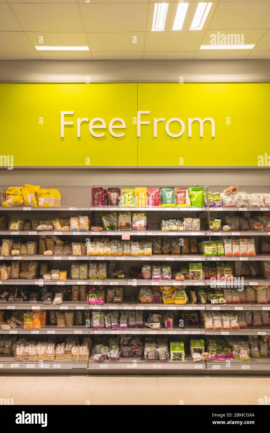 Sign showing the text Free From - gluten, lactose,  dairy and soya free aisle with products on shelves in Waitrose supermarket, Basingstoke, UK Stock Photo