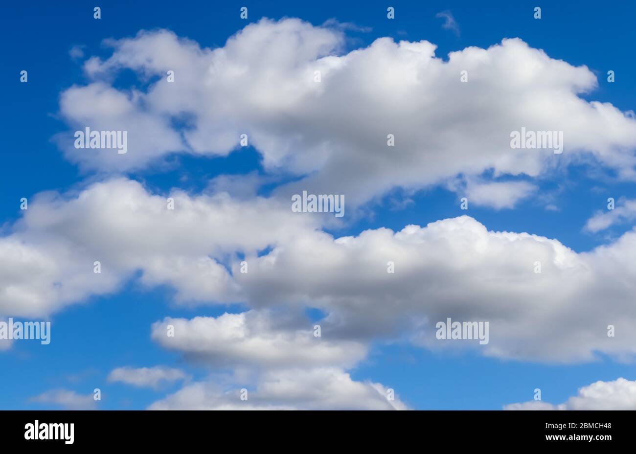 Beautiful white fluffy clouds in a deep blue summer sky Stock Photo - Alamy