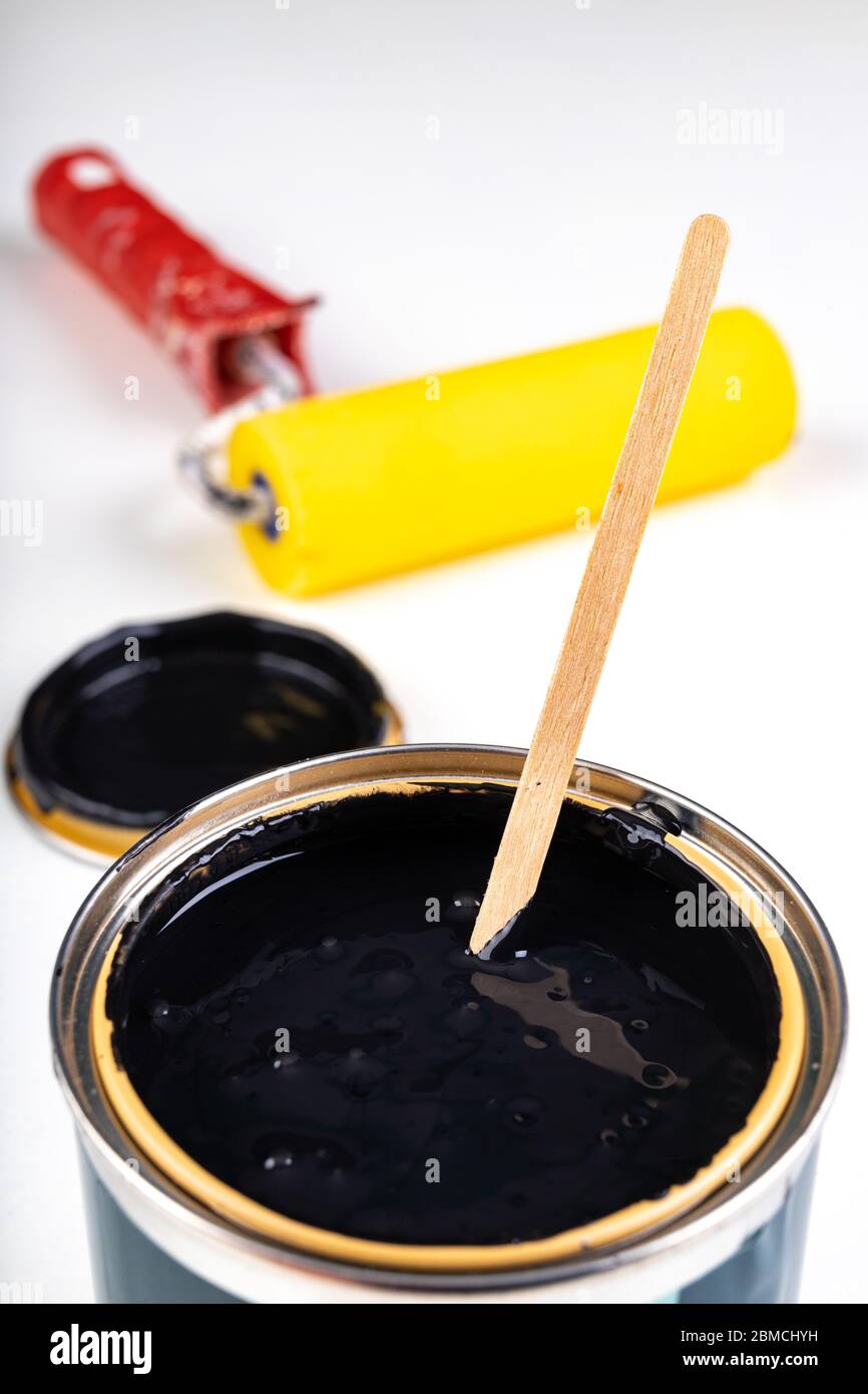 Black paint can and paint roller. Paint application accessories. Light background. Stock Photo