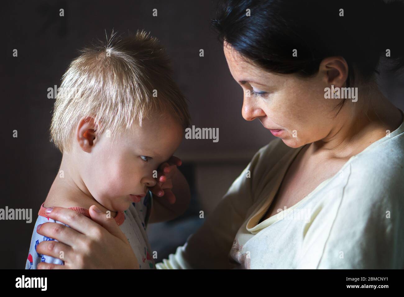 Tired mother hugging and calming little cute sad upset crying caucasian
