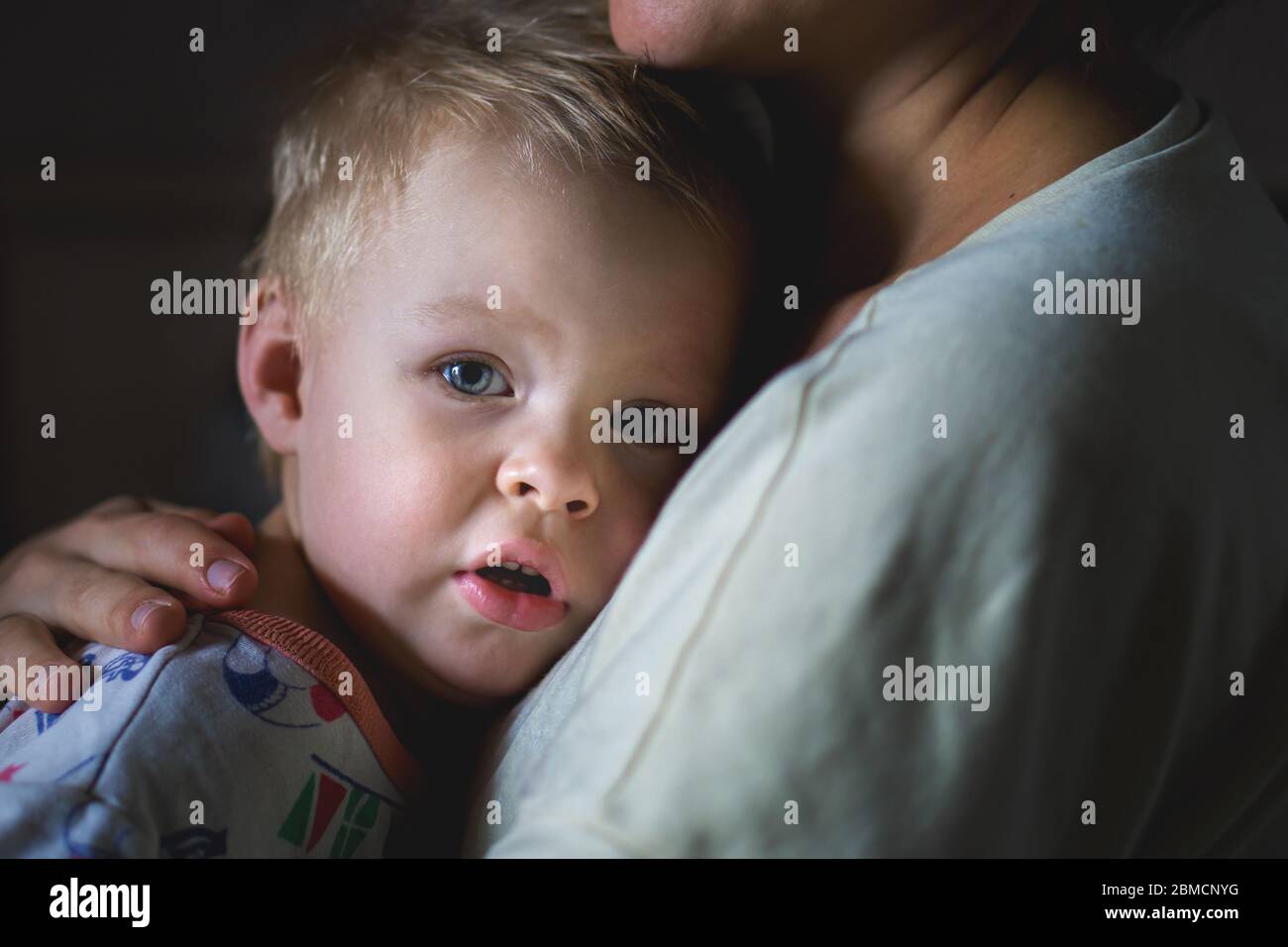 A tearful little boy clings to his mother to calm down. A mother's care and custody. The relationship between parents and children Stock Photo