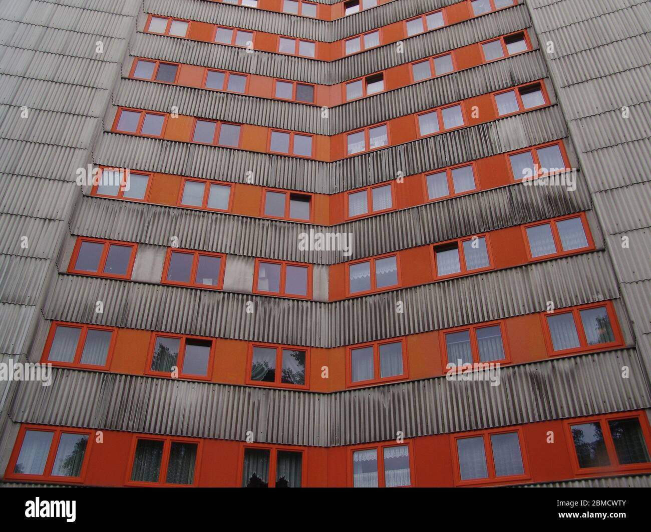 Beton Hochhaus orange rote Fenster in Berlin Stock Photo
