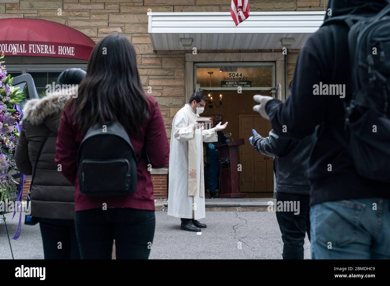New York, NY May 8, 2020 Priest prays and reads portion of Bible at