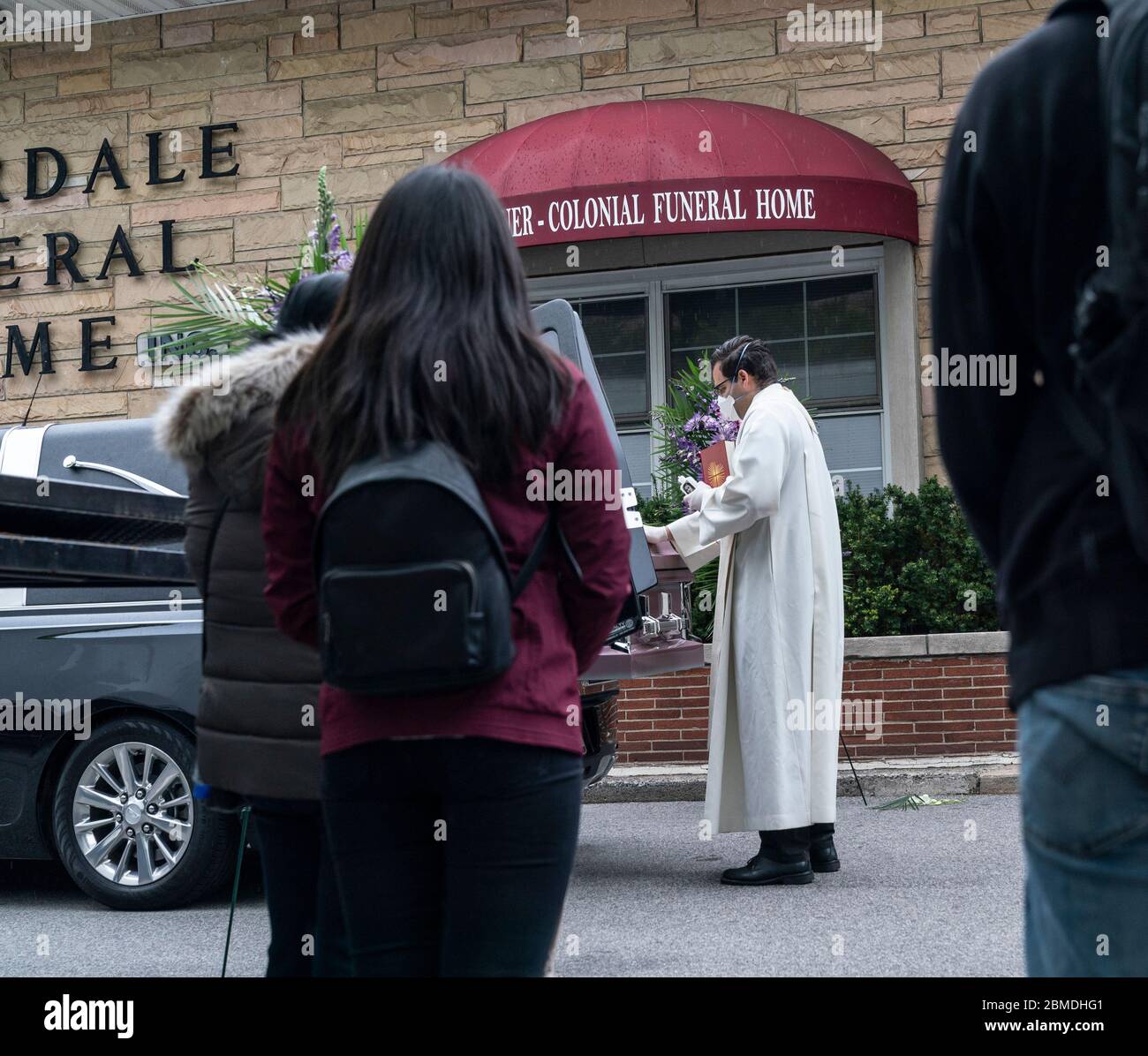 New York, NY May 8, 2020 Priest prays and reads portion of Bible at