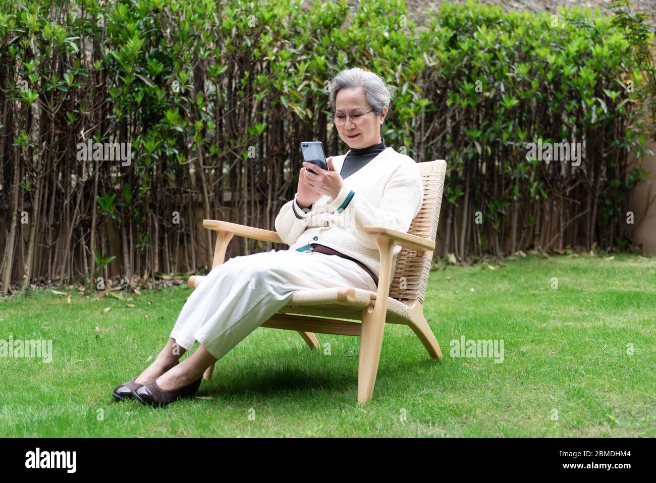An Asian elderly woman is using a smartphone Stock Photo