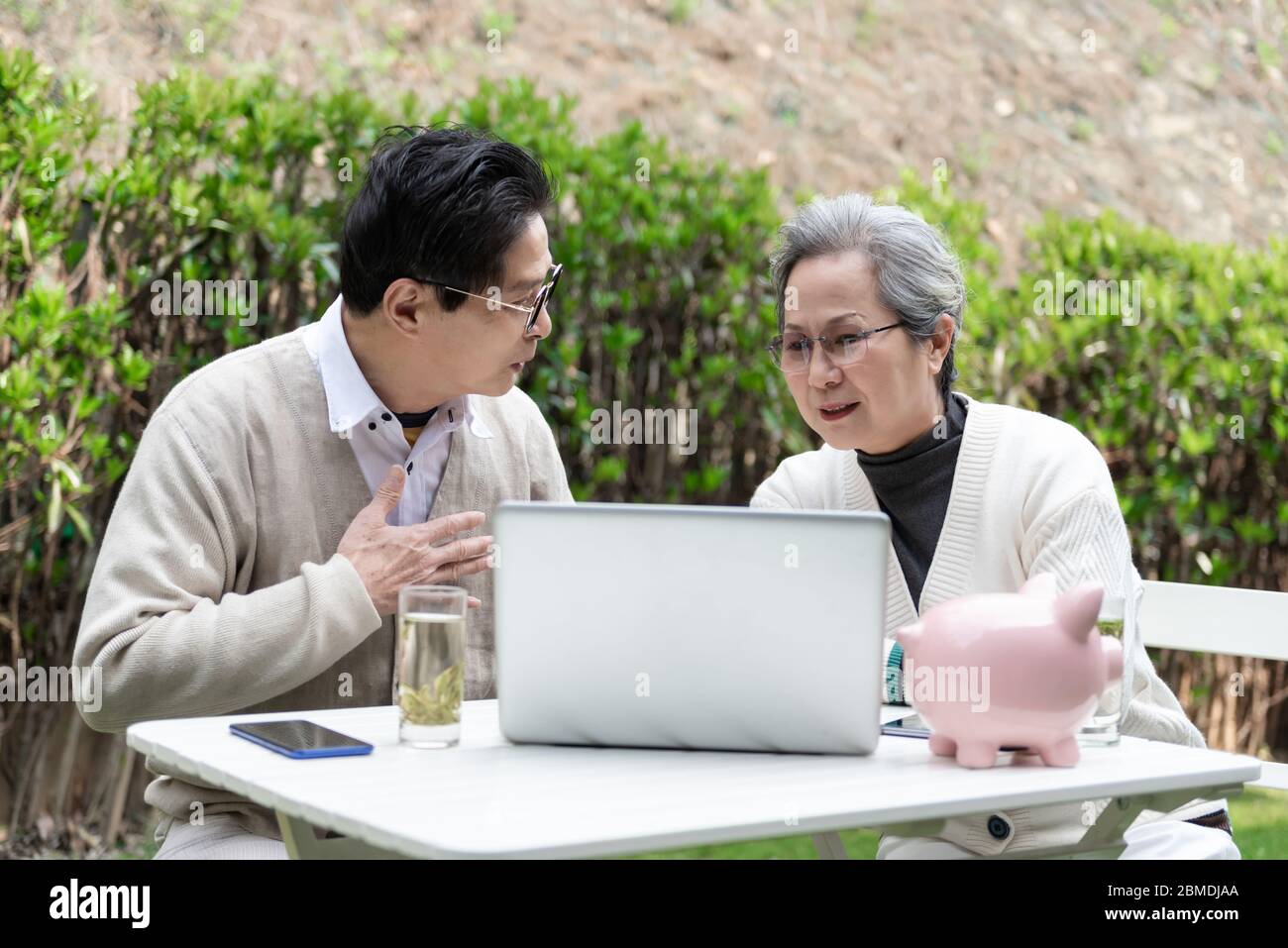 An Asian elderly couple is using a laptop Stock Photo