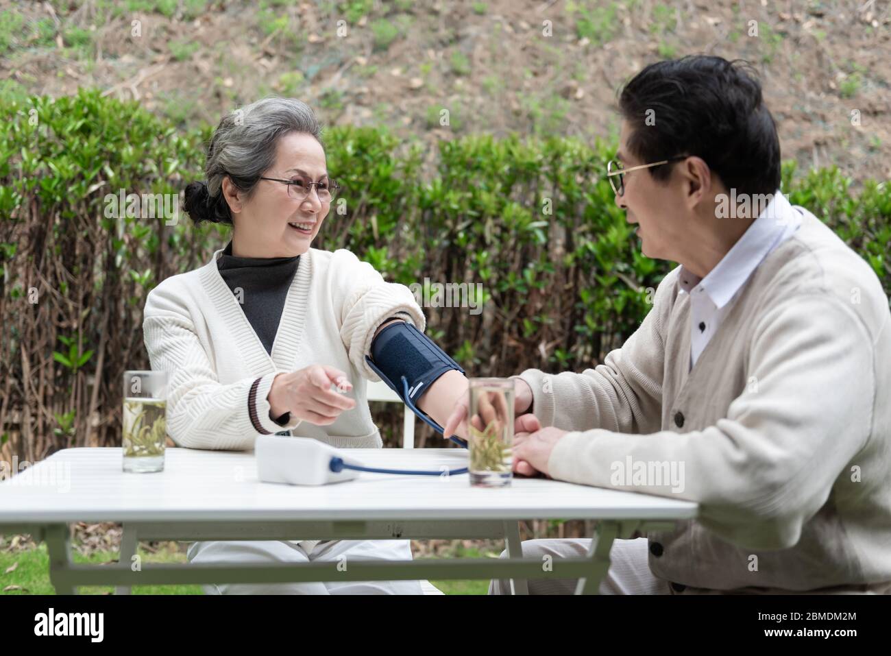 An Asian elderly couple is measuring blood pressure Stock Photo