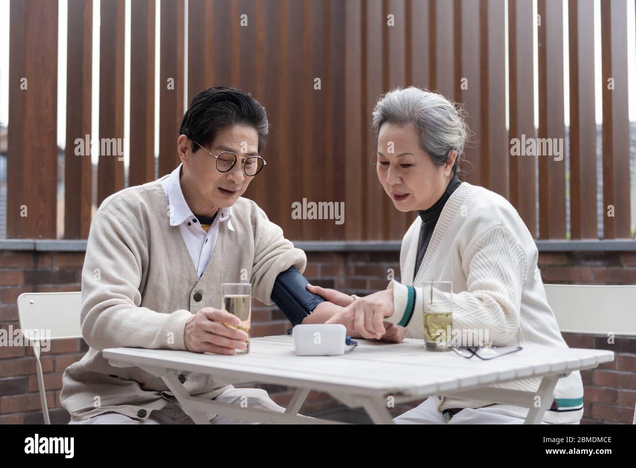 An Asian elderly couple is measuring blood pressure Stock Photo