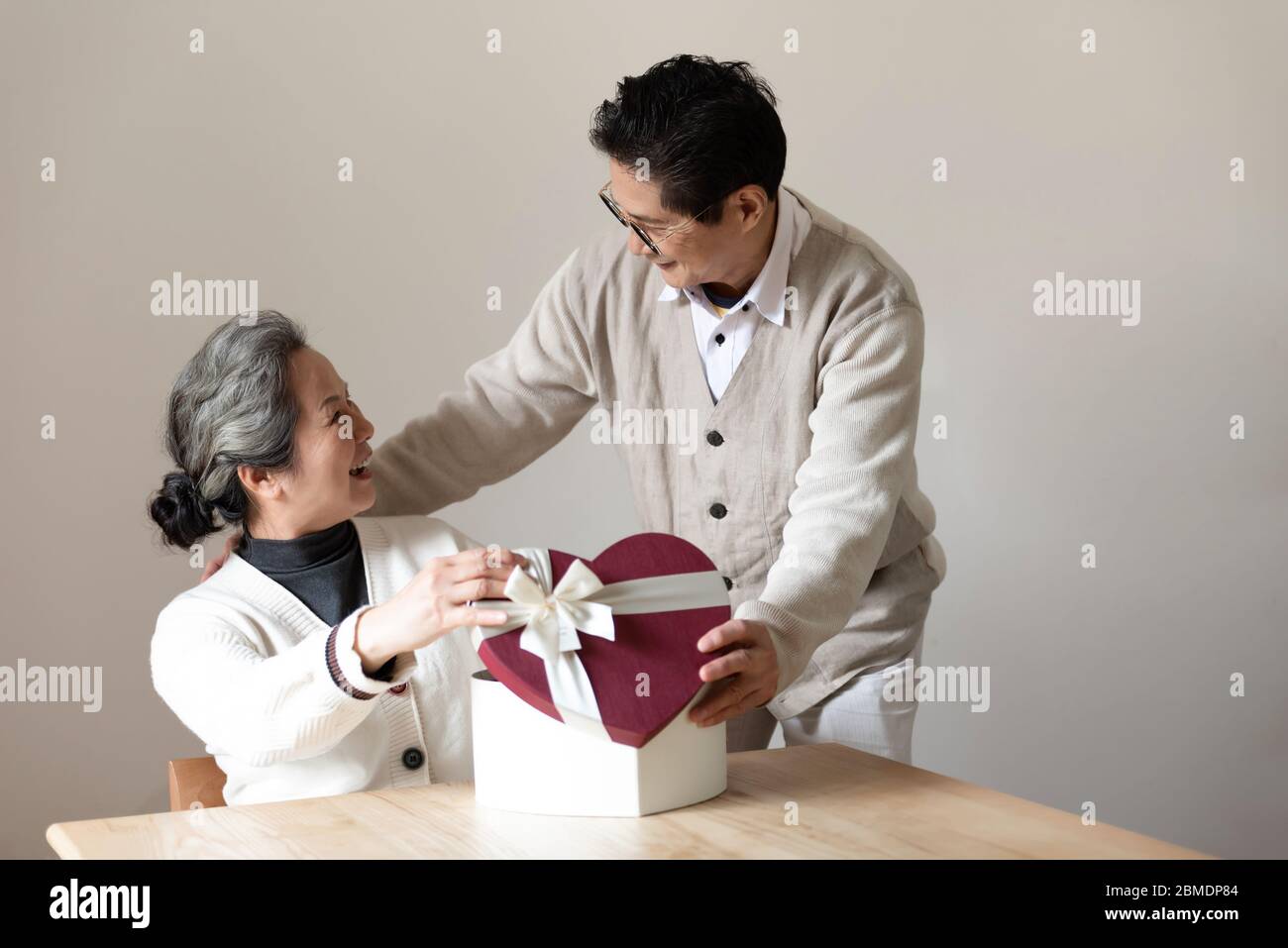 An Asian elderly couple sitting at the table Stock Photo