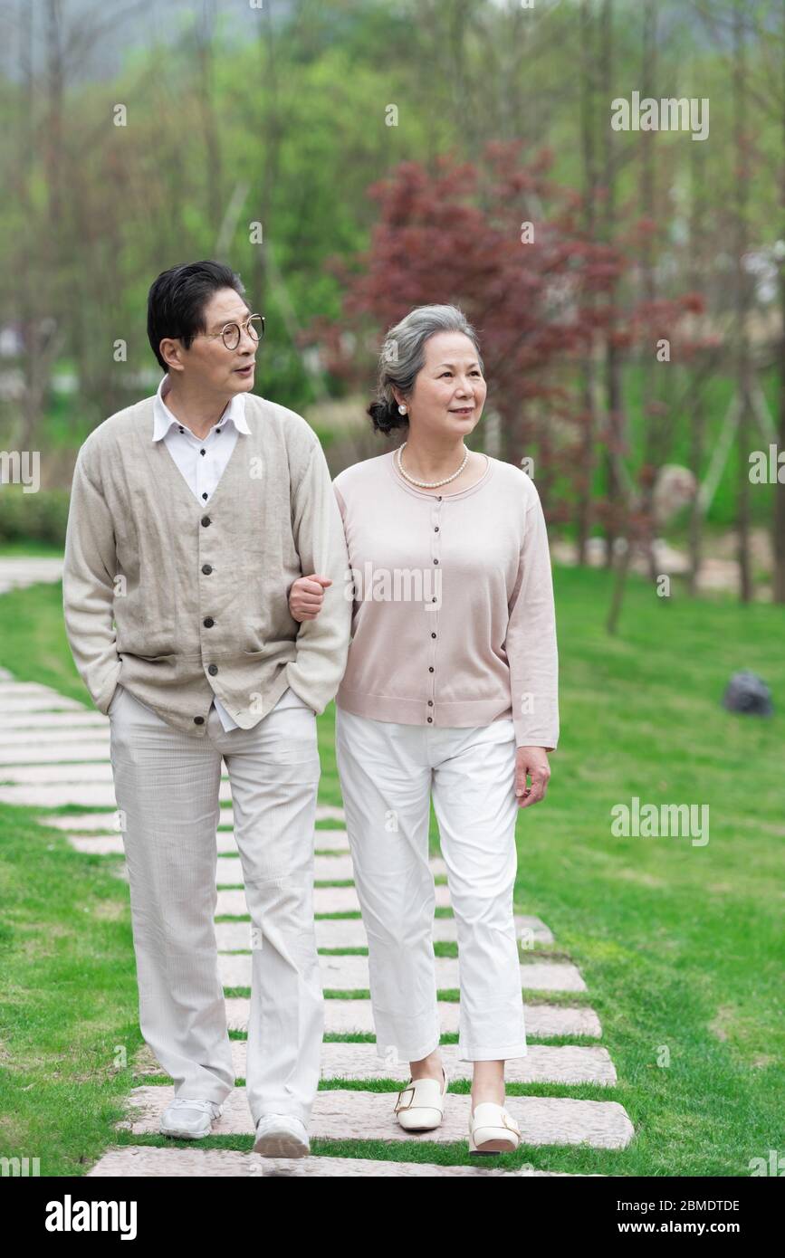 An Asian elderly couple walking in the park Stock Photo - Alamy