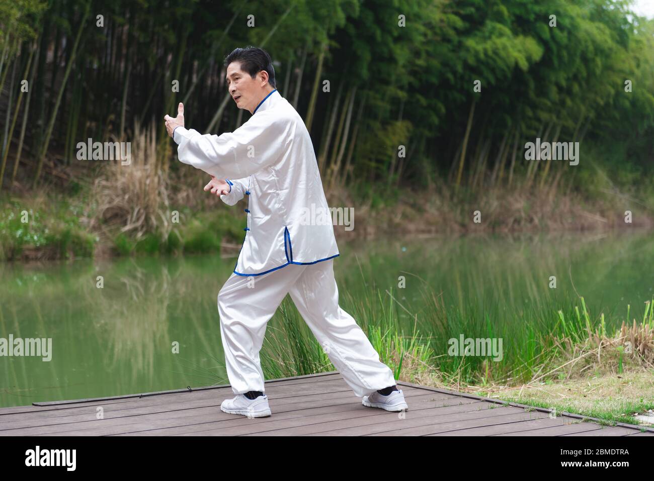 An Asian elderly man doing sports by the lake Stock Photo
