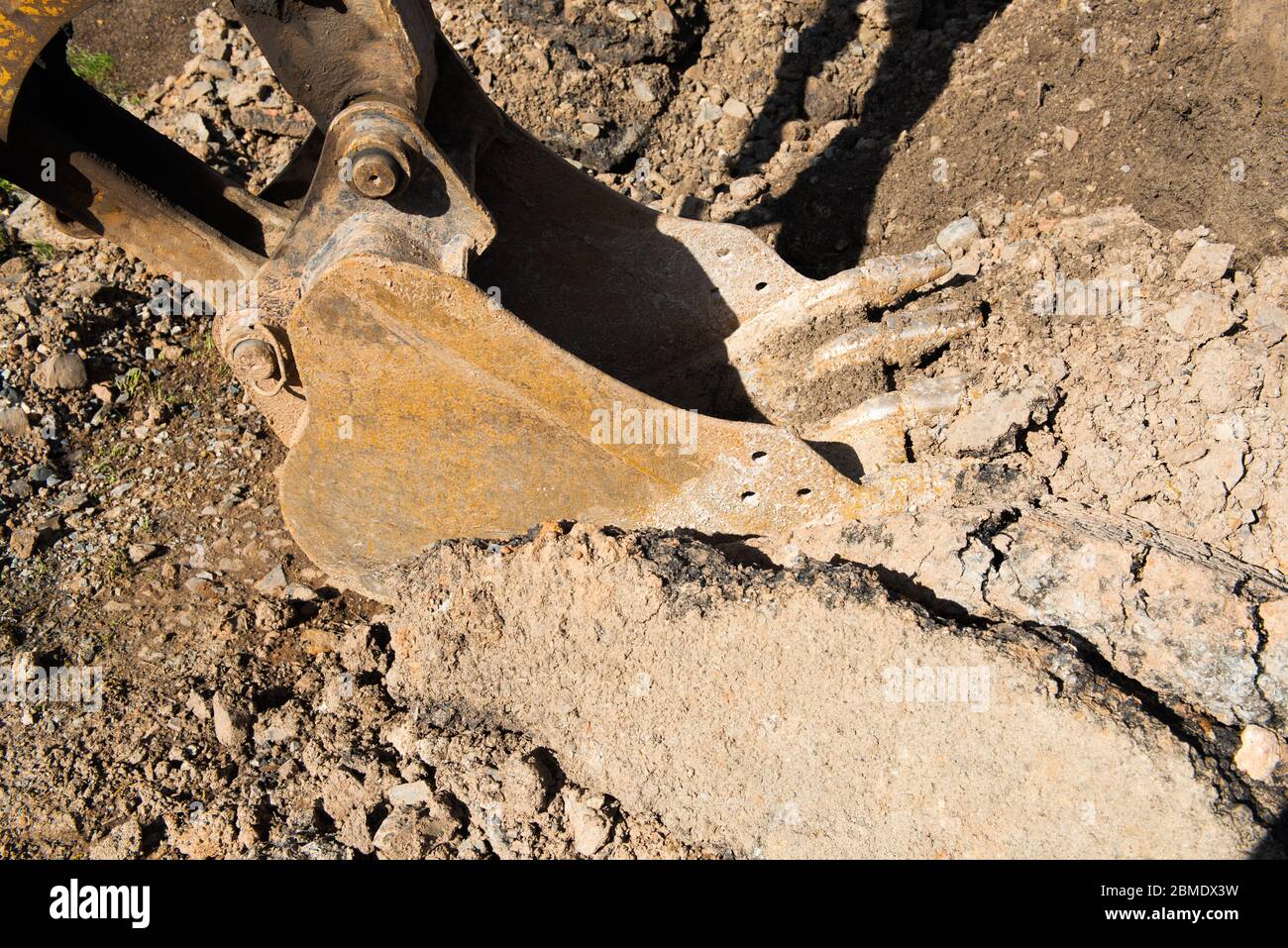 Backhoe scoop at a construction site, digging up dirt for a building project. Stock Photo