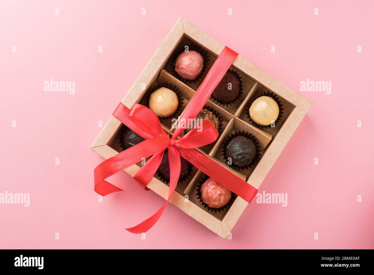 Set of different chocolates in a paper box with a satin purple ribbon