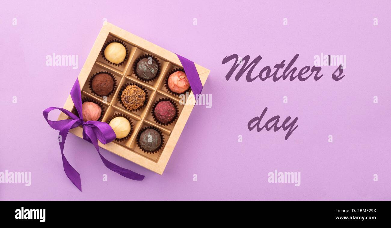 Set of different chocolates in a paper box with a satin ribbon on ...