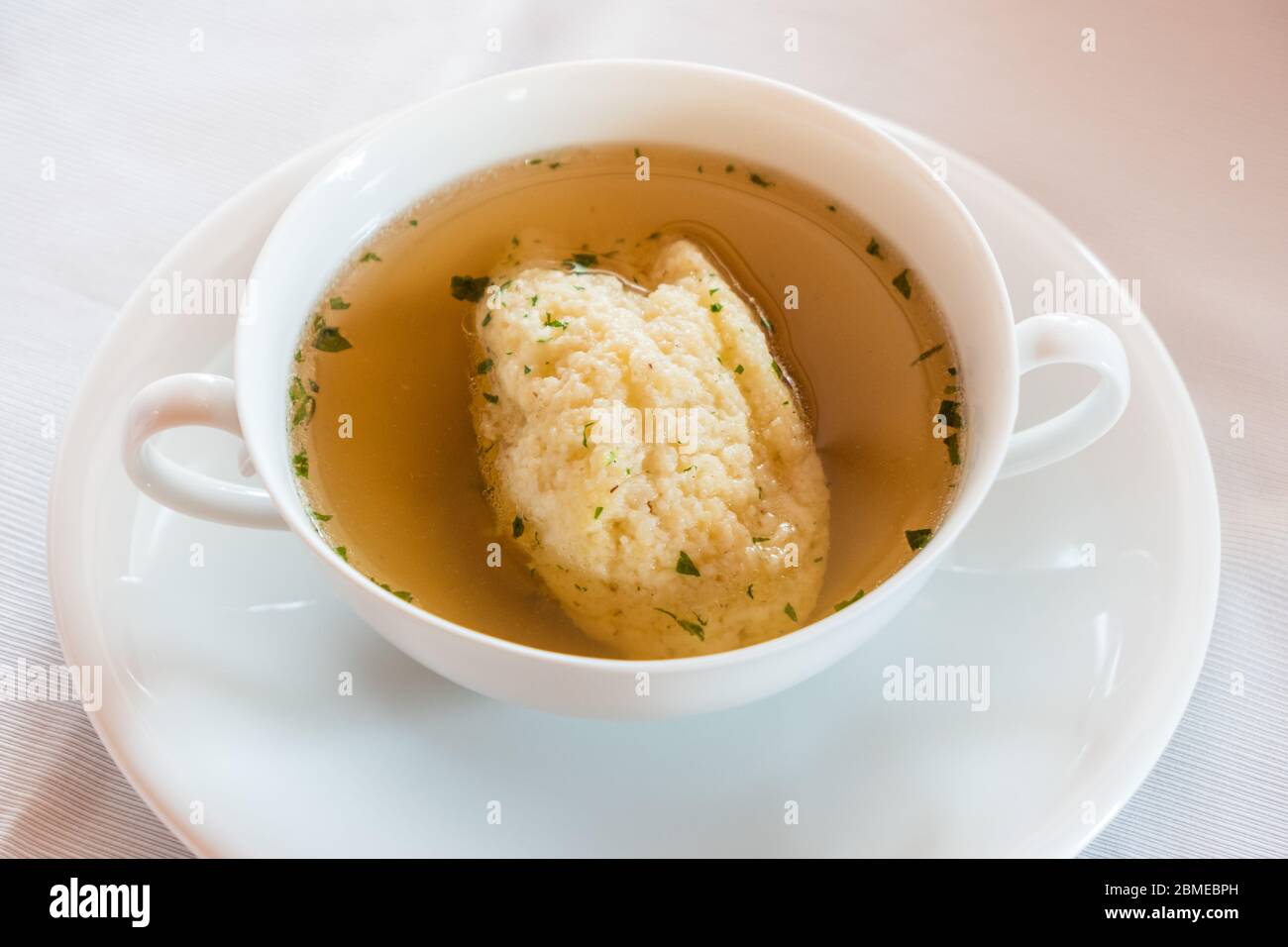 Semolina Dumpling Soup, Beef Broth with Parsley in a White Bouillon Cup, a Specialty of Austrian and Viennese Cuisine Stock Photo