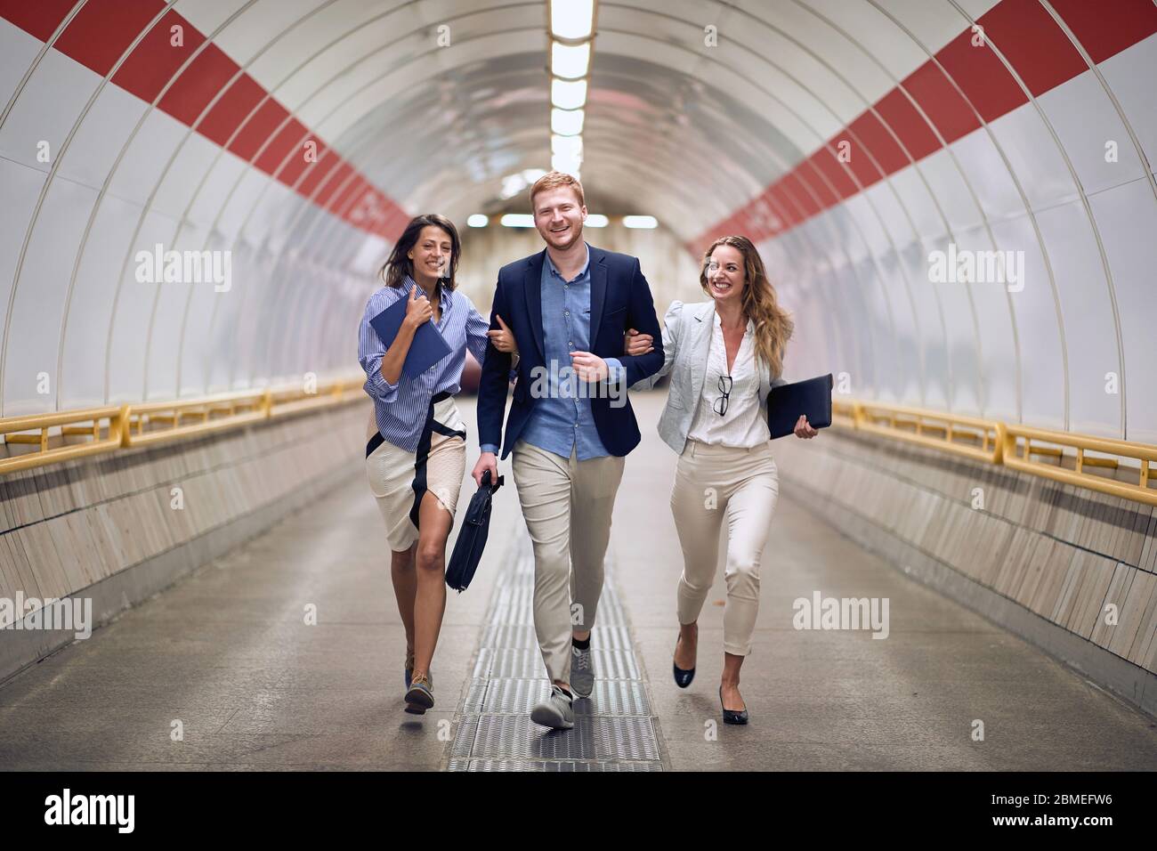 Successful business people In the subway station.Young people walking to platform at train station.Urban lifestyle and transportation concepts. Stock Photo