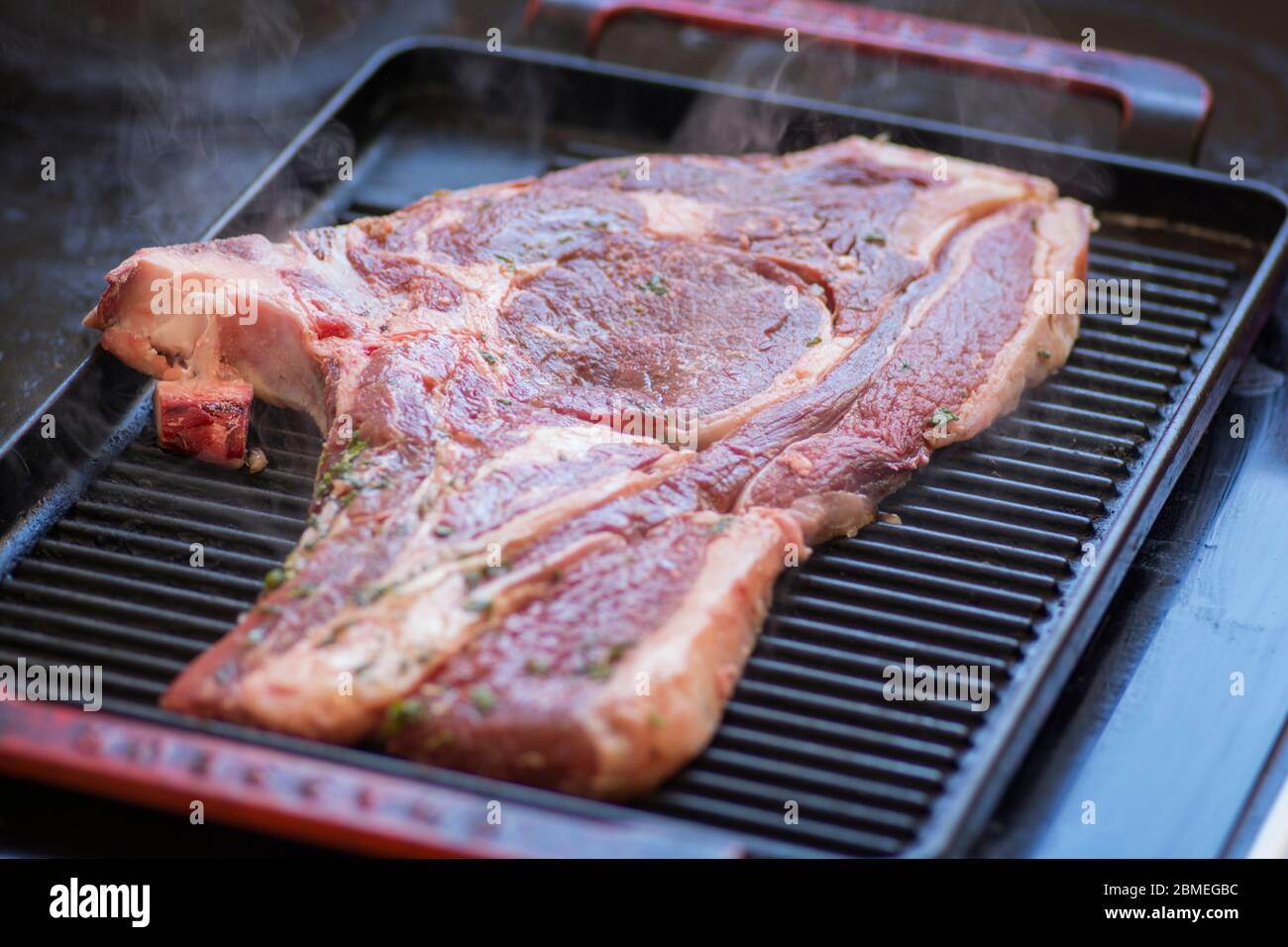 Close up view of a raw steak, a Sirloin cut, being grilled on a