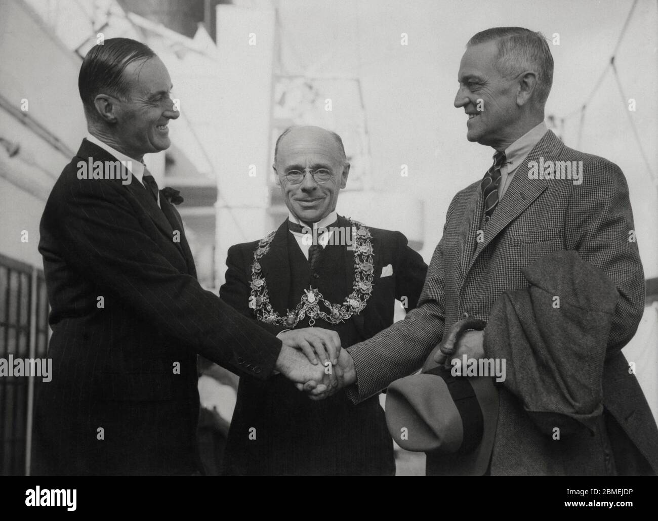Malcolm Campbell (1885-1948), piloto automovilista británico, récord mundial de velocidad con su automóvil Pájaro Azul en las pistas de Utah, Estados Unidos, saludando al embajador norteamericano B.W. Bingham en presencia del alcalde de Southampton. Año 1935.. Stock Photo