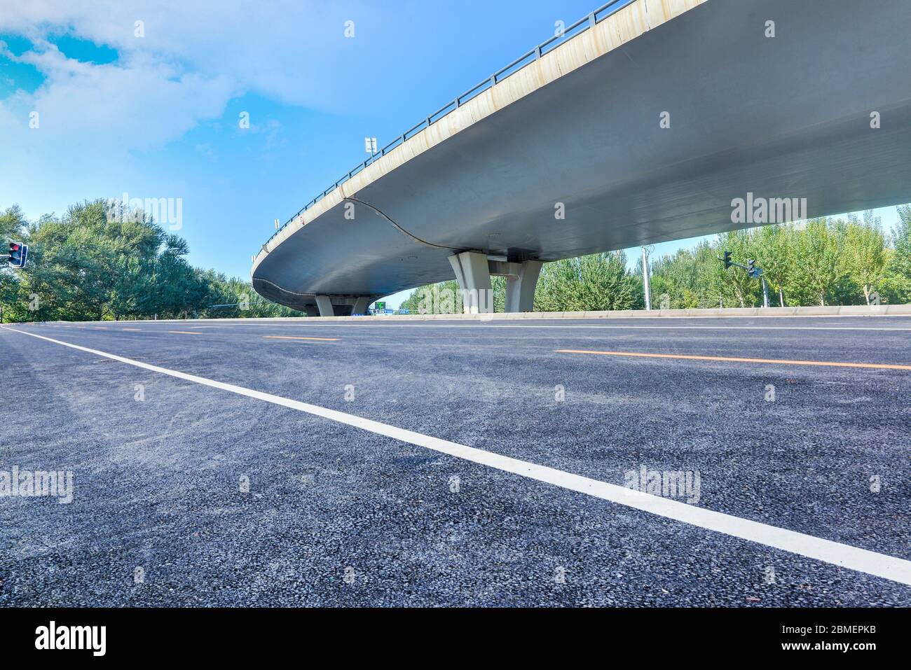Under the overpass, car-free asphalt road, modern city building skyline as background. Stock Photo
